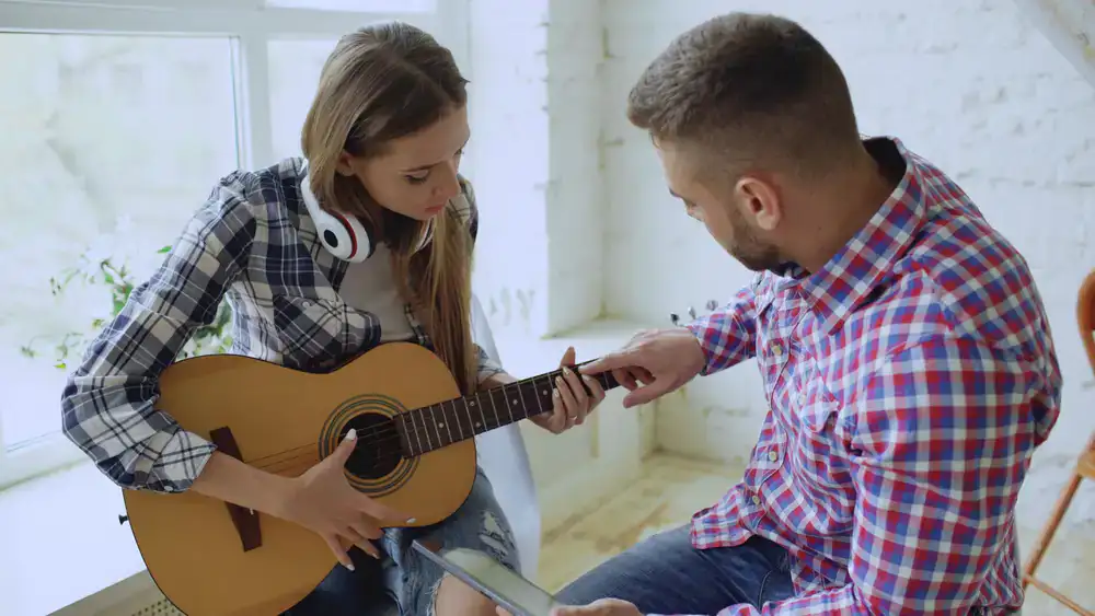 Lead guitar instructor playing an acoustic guitar